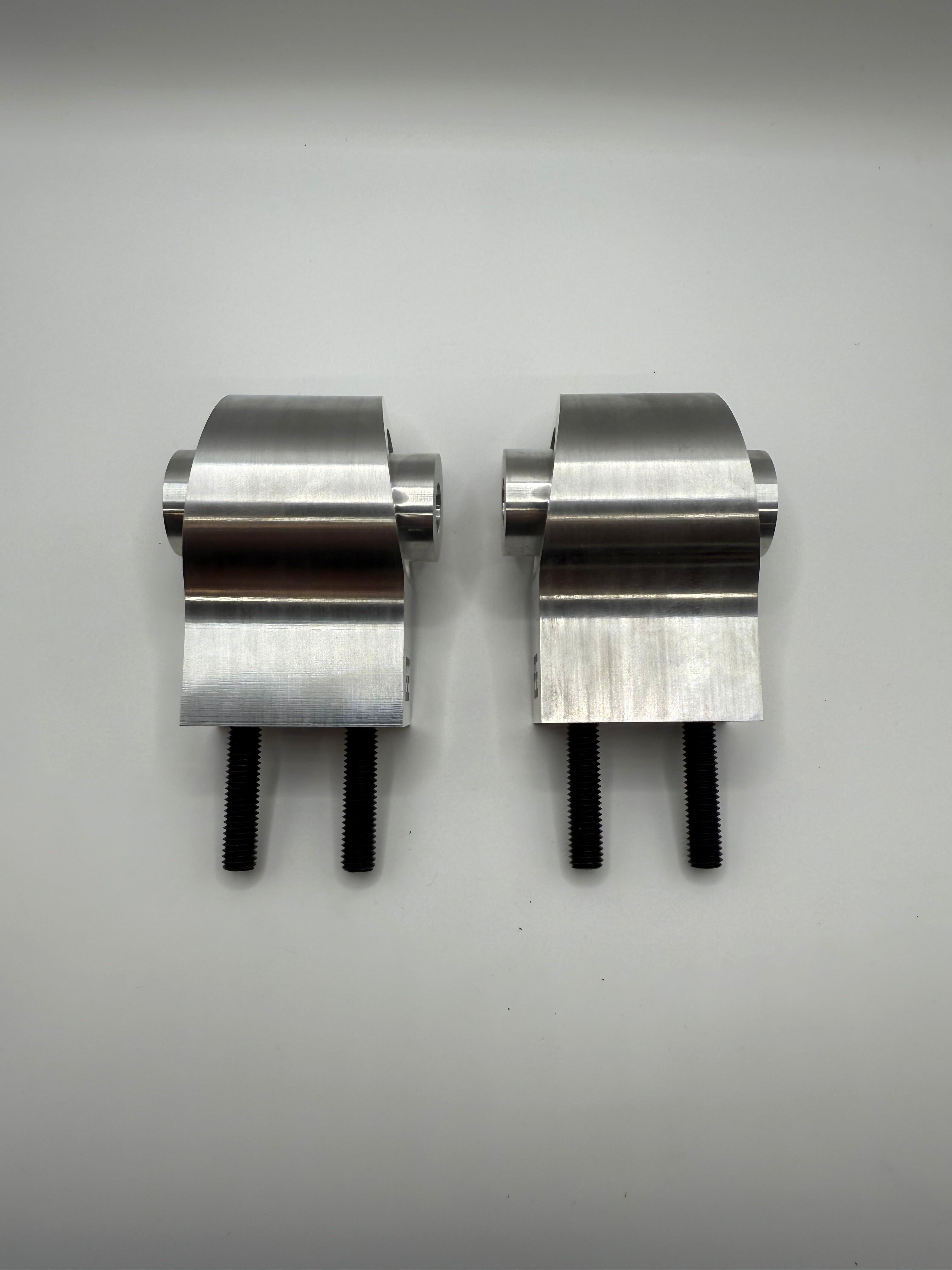 Pair of stainless steel valve controller brackets with black bolts on white background