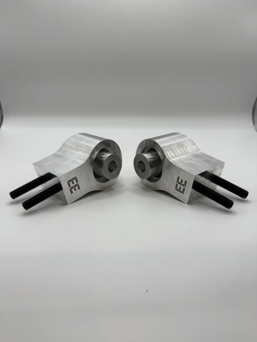 Pair of Eastwood Engineering machined metal performance parts with EE logo, on white background