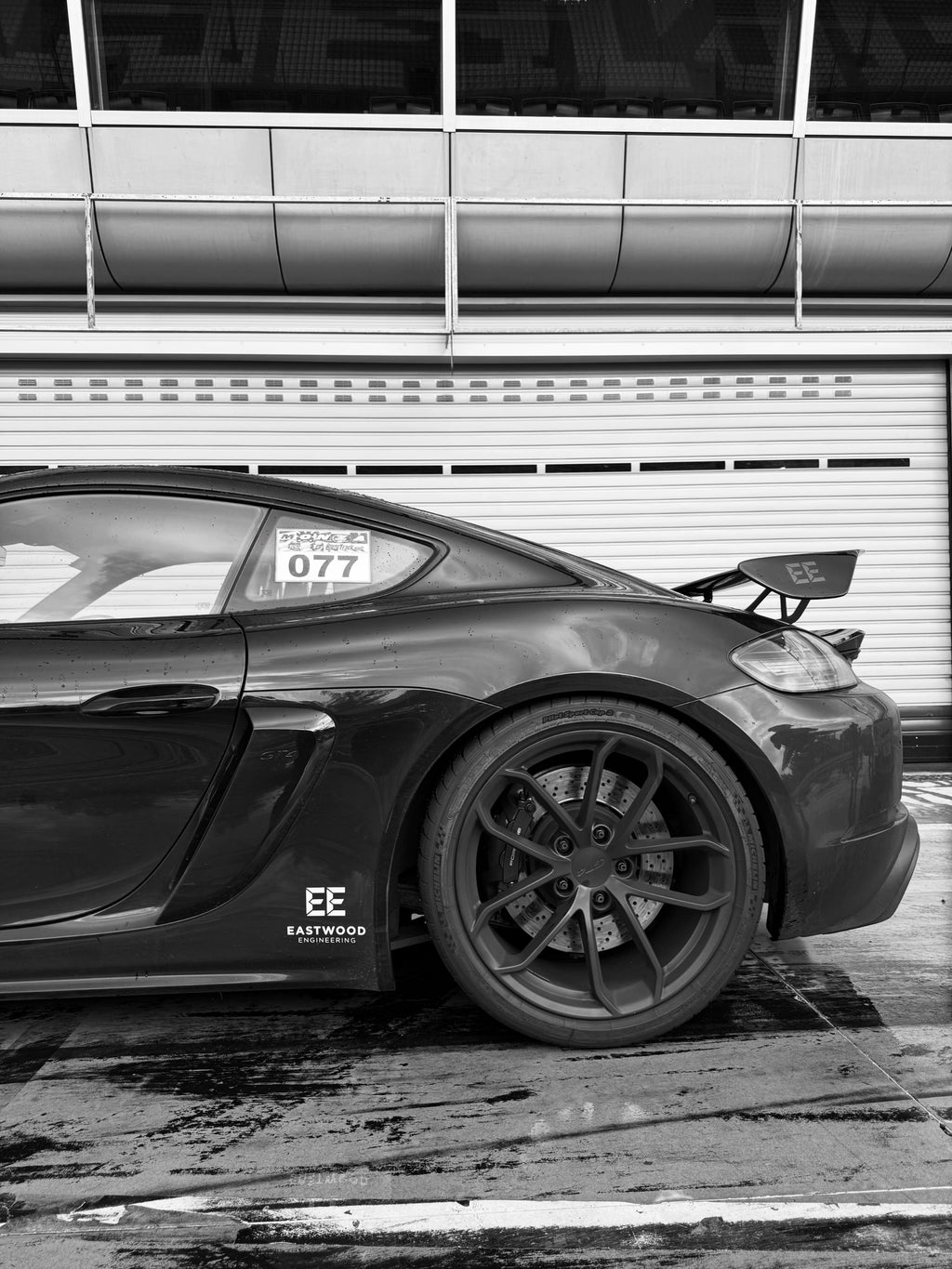 Black sports car with Eastwood Engineering logo and performance parts, side view on track